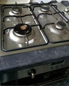 Gas hob covered in burnt-on grease before cleaning in a Cork kitchen