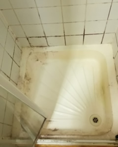 Shower tray with mould, limescale and staining before deep cleaning