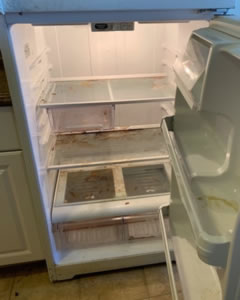 Dirty fridge interior with spills and stains before cleaning
